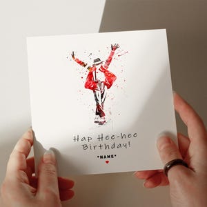 a person holding up a card with a painting of a man in a red jacket