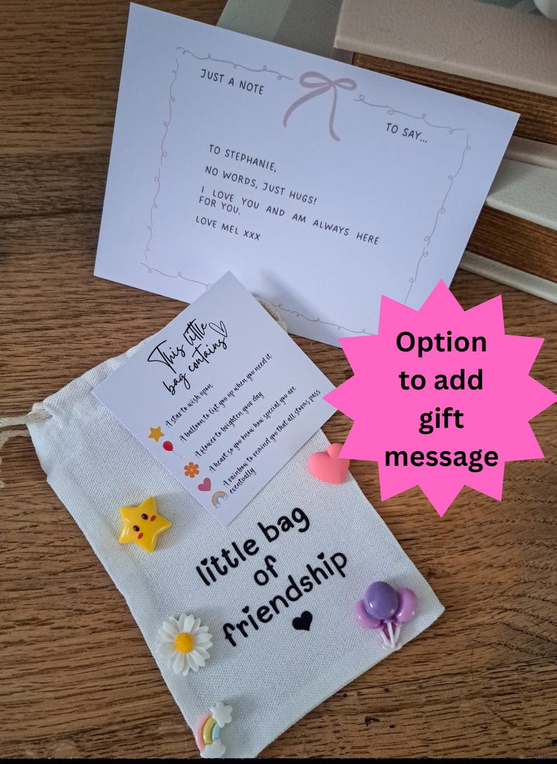 May include: A white fabric drawstring pouch labeled little bag of friendship with small resin charms including a yellow star, white daisy, purple balloons, and a rainbow. A card reads This little bag contains and a note says JUST A NOTE TO SAY...