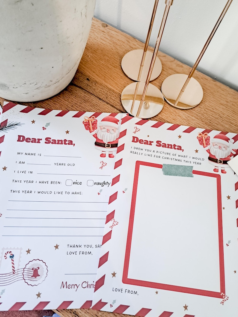 May include: A festive Christmas letter to Santa Claus, featuring a red and white border design with Santa Claus illustrations. The letter includes fill-in-the-blank sections for the child's name, age, and desired gifts. Gold-colored place card holders are in the background.