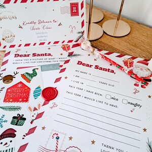 May include: A set of Christmas-themed stationery, including a letter to Santa Claus, an envelope, and a decorative pen. The letter features festive illustrations and the text "Dear Santa." The envelope is addressed to Santa Claus.