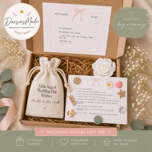 Pode incluir: Uma caixa de presente de papelão contendo uma bolsa de tecido creme estampada com Little bag of Wedding Day Wishes For Mr & Mrs Smith, uma rosa artificial branca e um cartão listando pequenos objetos como estrela, coração e flor.