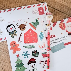 May include: Christmas-themed stationery set with stickers, a pencil, and envelopes. The stickers feature festive characters like a penguin, reindeer, and snowman, along with candy canes and a Christmas tree. The pencil has a Santa topper.