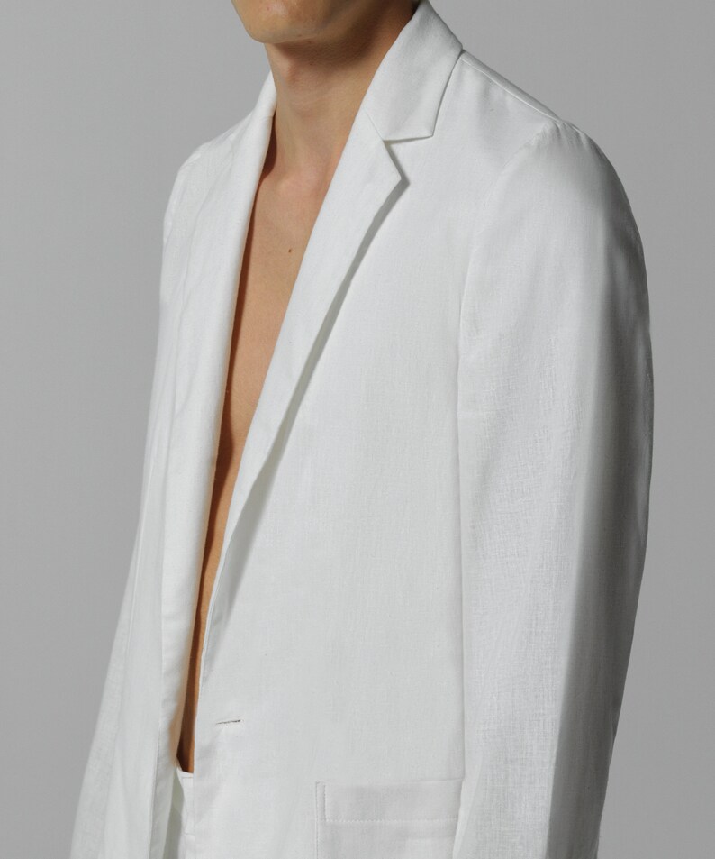 May include: A white linen blazer with a notched collar and a single button closure. The blazer has a pocket on the left side and a smooth, textured fabric.