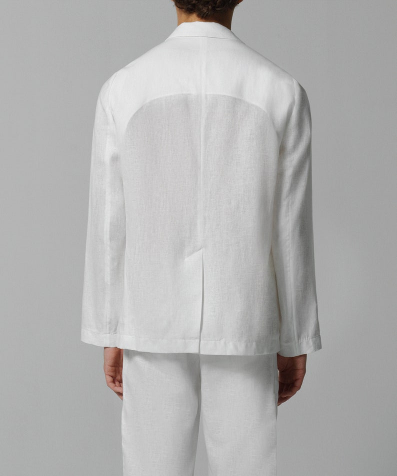 May include: A white linen blazer with a relaxed fit. The blazer has a single button closure and a welt pocket on the back.