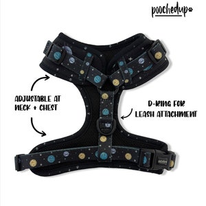 May include: A black dog harness with a space-themed print featuring planets and stars. The harness has adjustable straps at the neck and chest and a D-ring for leash attachment. The brand name "pooched up" is printed on the strap.