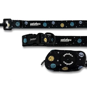 May include: A black dog leash, collar, and poop bag holder with a space-themed print featuring planets, stars, and the text "poochedup" on each item.