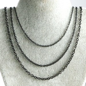 May include: Four black chain necklaces of varying lengths, displayed on a grey mannequin.