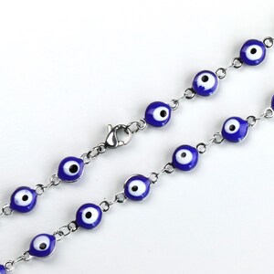May include: A silver chain bracelet with blue and white evil eye charms. The bracelet has a lobster clasp closure.