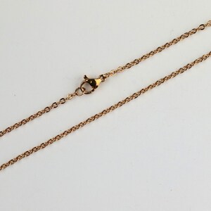 May include: A gold chain necklace with a lobster clasp closure.