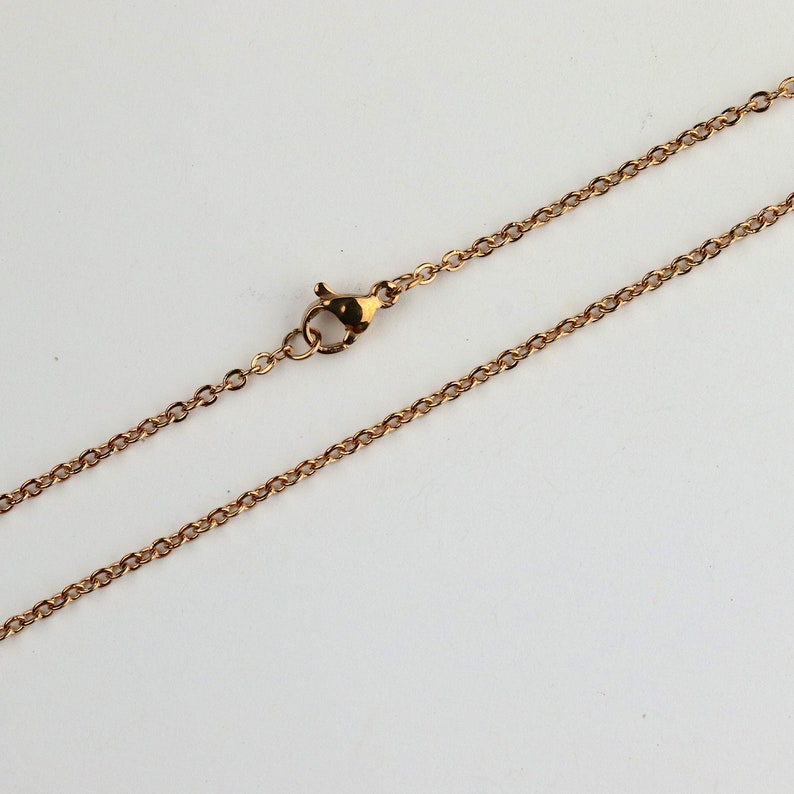 May include: A gold chain necklace with a lobster clasp closure.