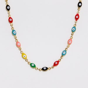 May include: A gold chain necklace with colorful evil eye charms. The charms are oval-shaped and have a black pupil in the center.