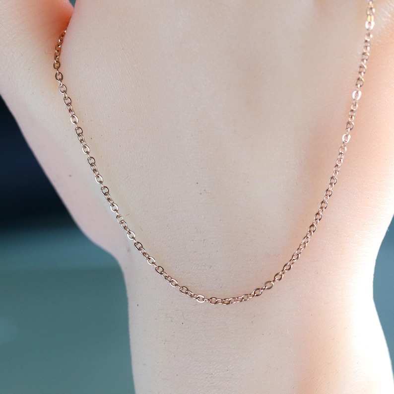 May include: A rose gold chain necklace with a delicate, linked chain design.