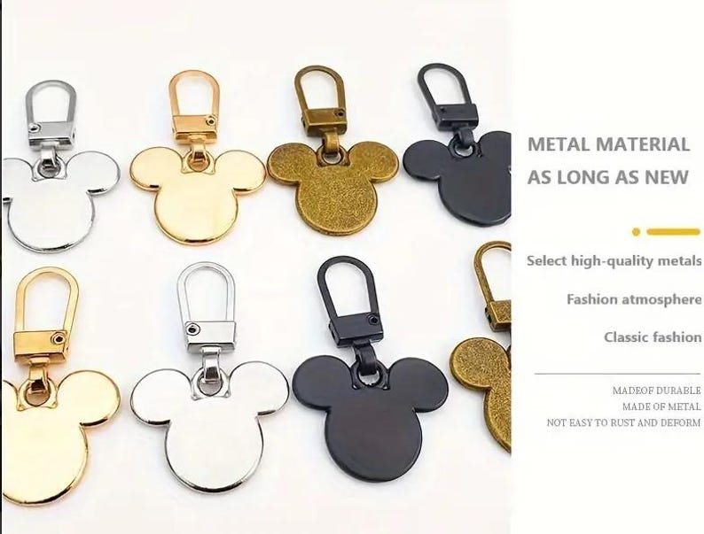 Op de afbeelding: Assortiment van zes metalen Mickey Mouse rits-trekkers in goud, zilver, zwart en brons. De rits-trekkers zijn gemaakt van duurzaam metaal en zijn niet gemakkelijk te roesten of te vervormen.