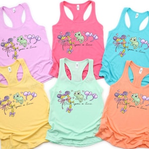 Puede incluir: Seis camisetas sin mangas de diferentes colores: rosa claro, rosa fuerte, turquesa, amarillo, verde menta y melocotón. Cada camiseta tiene un gráfico con un camaleón de dibujos animados, un lazo y el texto "Once upon a time."