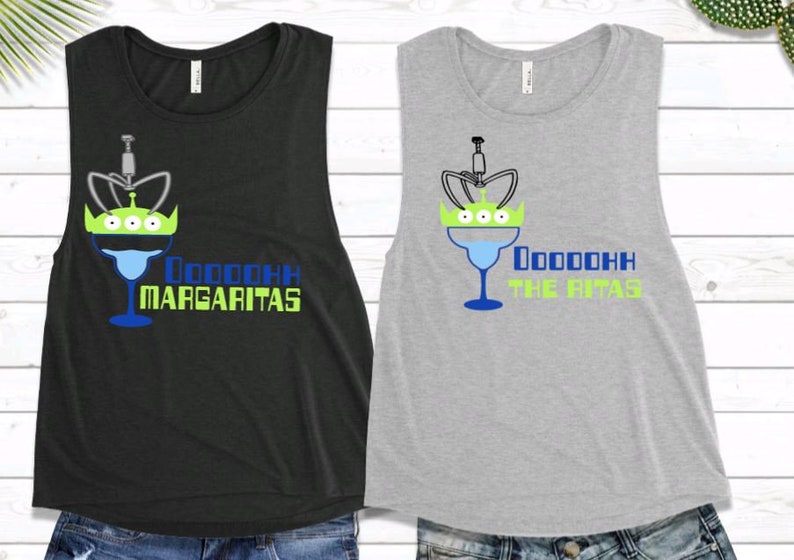 May include: Two sleeveless shirts with a graphic of a margarita glass with a green alien head on top. The text on the black shirt says "Ooooooh Margaritas" and the text on the gray shirt says "Ooooooh The Ritas".