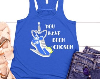 May include: A royal blue tank top with a white graphic of a running shoe with a green alien character. The text "You Have Been Chosen" is printed on the shirt.