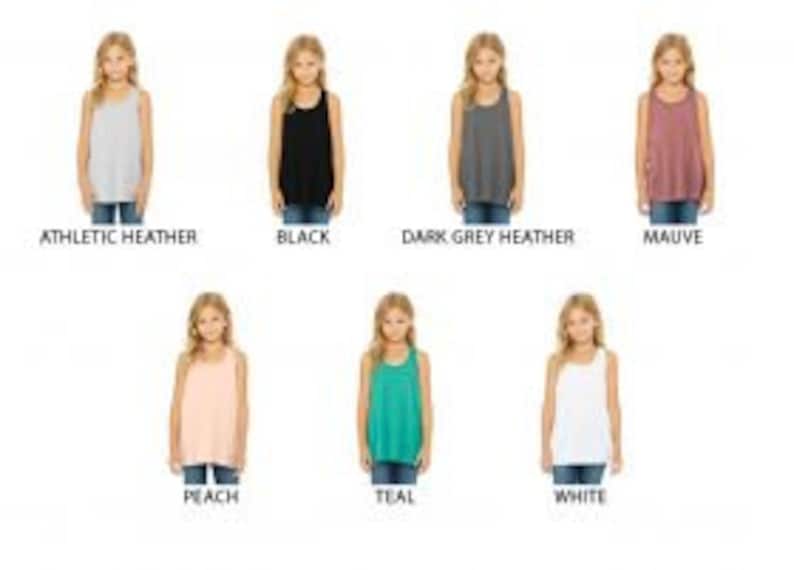 May include: A set of 10 girls' tank tops in various colors, including athletic heather, black, dark grey heather, mauve, peach, teal, and white.