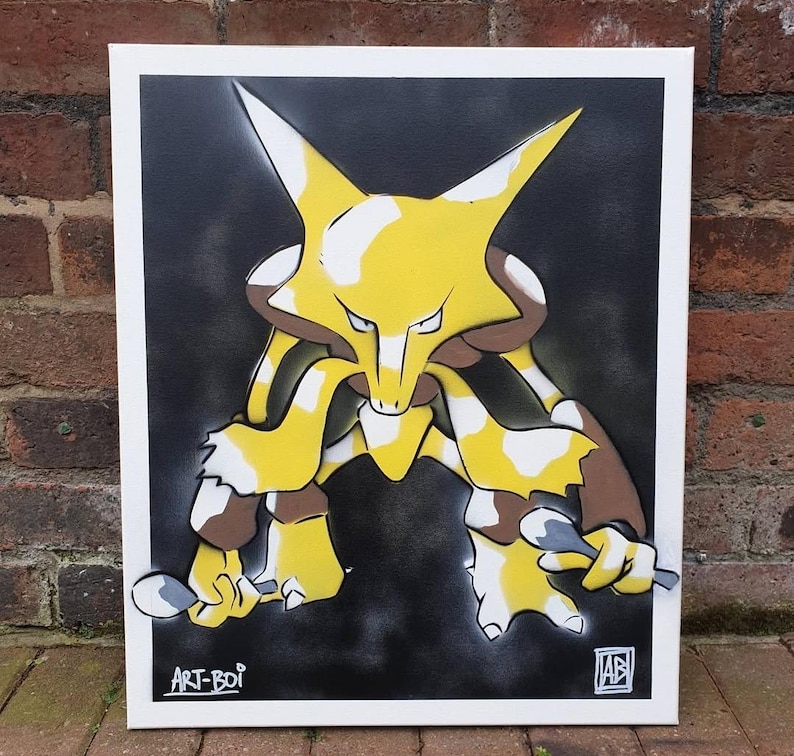 May include: A framed artwork featuring a yellow and brown cartoon character against a black and gray background. The character has large ears and is holding two spoons. The artwork is signed "ART-BOI" and "AB".