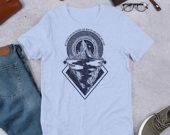 May include: A light blue t-shirt with a graphic design of a mountain range, a lake, and stars. The design is surrounded by a circle with the text "WITH MOUNTAINS AND OCEANS AND WINTERS AND RIVERS AND STARS".