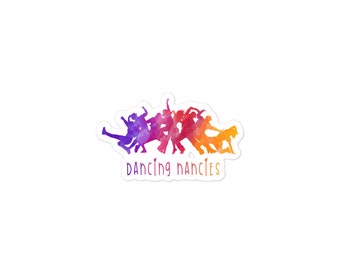 May include: A sticker with a watercolour design of dancing figures in purple, red, and orange hues. The text "Dancing Nancies" is written in a cursive font below the figures. The sticker has a white border.