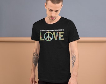May include: A black t-shirt with a peace sign and the text "ALL YOU NEED IS, WHAT YOU WANT IS, ALL YOU NEED IS LOVE" printed on the front.