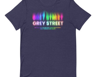 May include: A navy blue t-shirt featuring a rainbow-coloured graphic of the text "GREY STREET" and the text "BUT ALL THE COLORS MIX TOGETHER TO GREY AND IT BREAKS HER HEART."