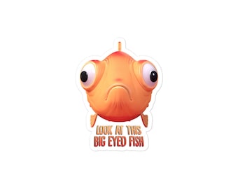 May include: A sticker featuring a cartoon fish with large, round eyes and a sad expression. The fish is orange and has a white belly. The text "LOOK AT THIS BIG EYED FISH" is printed below the fish.