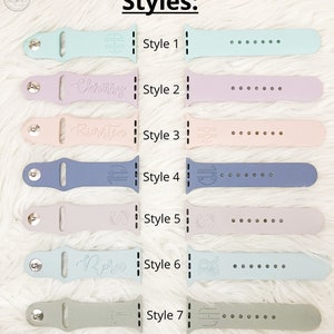 Pu&ograve; includere: Collezione di sette cinturini per orologi in silicone in vari colori pastello, tra cui verde menta, lavanda e azzurro. Ogni cinturino presenta un design unico, alcuni con iniziali o nomi. La parola "Styles:" &egrave; in alto.
