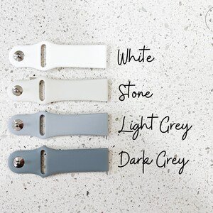 Pu&ograve; includere: Quattro cinturini per orologi bianchi, pietra, grigio chiaro e grigio scuro. Ogni cinturino ha una chiusura color argento. I colori sono etichettati con testo scritto a mano: Bianco, Pietra, Grigio chiaro e Grigio scuro.