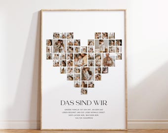 May include: A framed print featuring a heart-shaped collage of family photos. The print includes the text "DAS SIND WIR" and additional text below. The frame is a light wood color, and the background is white.