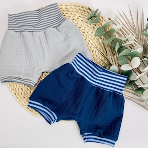 Könnte beinhalten: Zwei Paar Baby-Shorts mit gestreiften elastischen Bund. Ein Paar ist grau und das andere ist blau.
