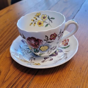 Tre (3) set Spode Copeland Gainesborough platta koppar och fat, krämfärgade med rosa, blå och gula transferware-blommor, gratinerade (3221)
