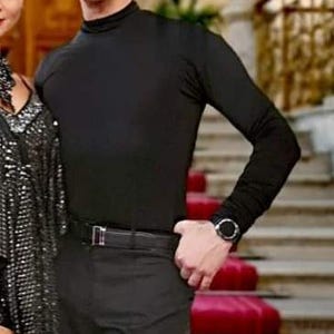 May include: A black long-sleeved mock neck shirt. The shirt is made of a smooth, stretchy fabric.