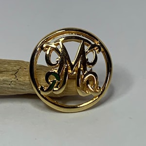 Elegante botón dorado con monograma M
