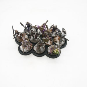 May include: A set of 10 miniature figures on a black base with a snowy landscape. The figures are painted in various shades of brown, green, purple, and black.
