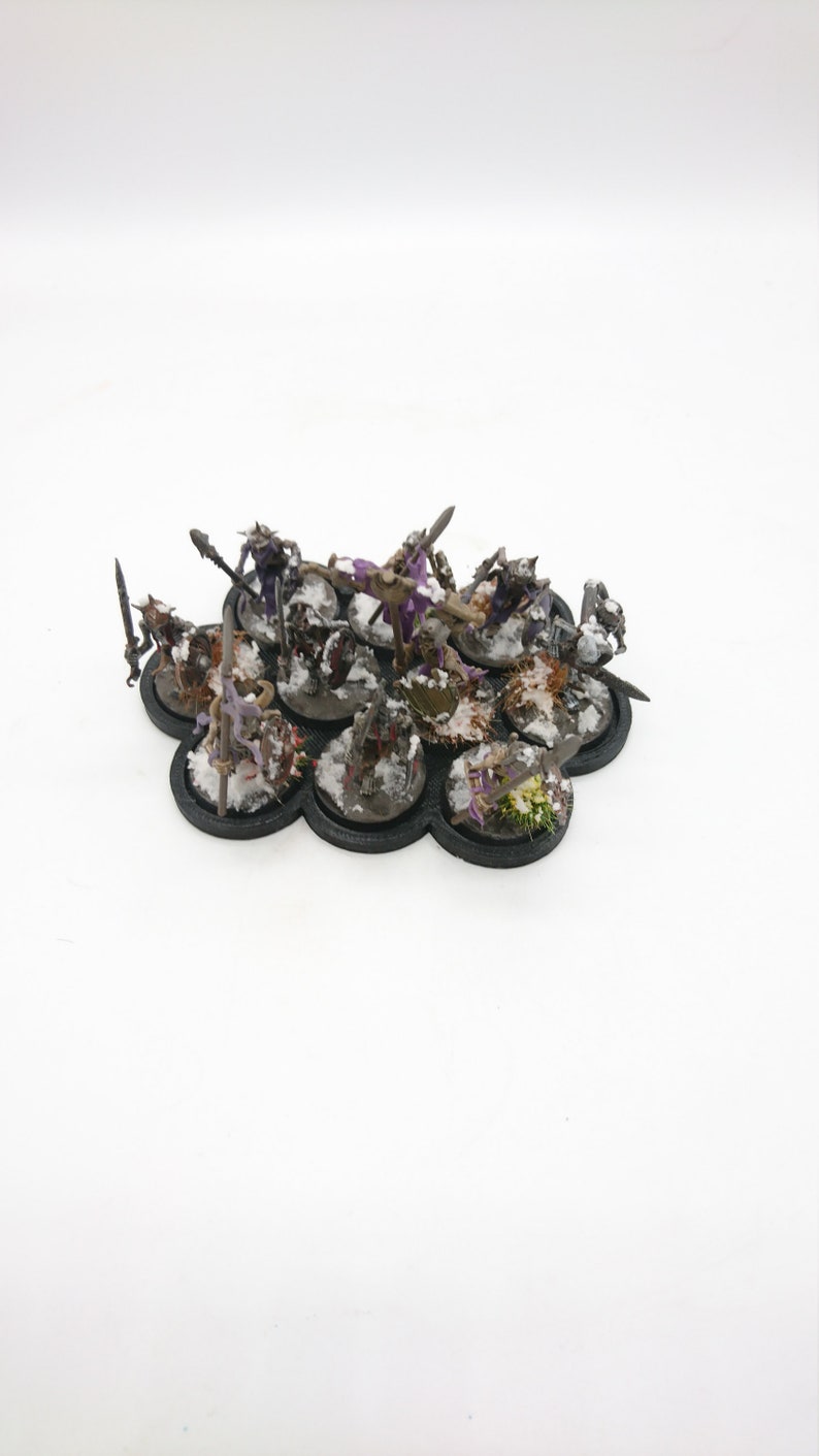 May include: A set of 10 miniature figures on a black base with a snowy landscape. The figures are painted in various shades of brown, green, purple, and black.