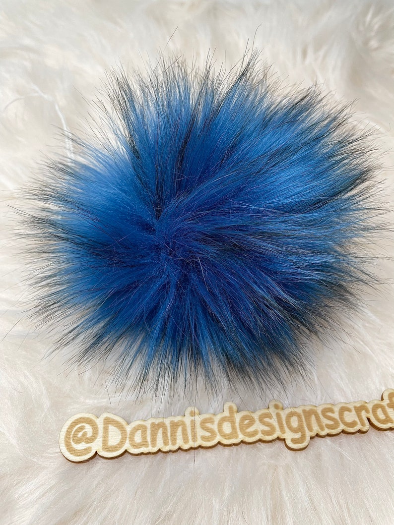 Peut inclure: Un pompon bleu et noir moelleux pour un chapeau ou un autre projet d'artisanat.