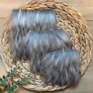 May include: Three pieces of faux fur in different sizes. The fur is a mix of gray and white, with a soft, fluffy texture.