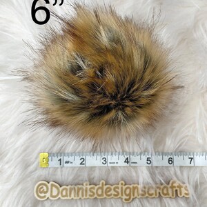 May include: A 6 inch faux fur pom pom in brown, black, and white colors. The pom pom is measured with a tape measure.