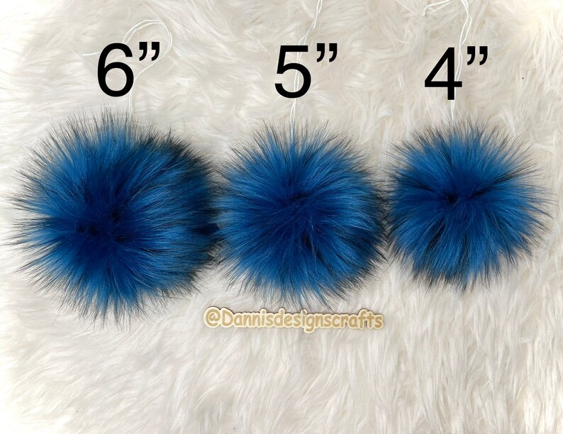 Peut inclure: Trois pompons en fausse fourrure bleue de diff&eacute;rentes tailles, 15 cm, 13 cm et 10 cm de diam&egrave;tre. Les pompons sont pr&eacute;sent&eacute;s sur une surface blanche et moelleuse.