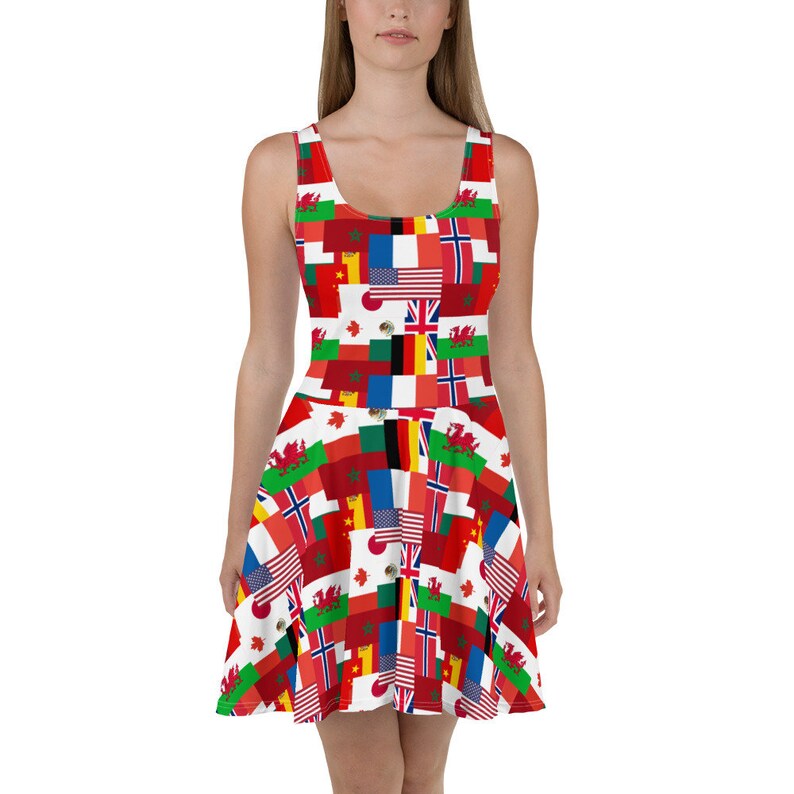 Puede incluir: Un vestido skater sin mangas con un estampado integral de varias banderas internacionales, incluidas las de Estados Unidos, Francia, Canad&aacute;, Jap&oacute;n y el Reino Unido, dispuestas en un patr&oacute;n de cuadr&iacute;cula colorido y repetitivo por toda la prenda.