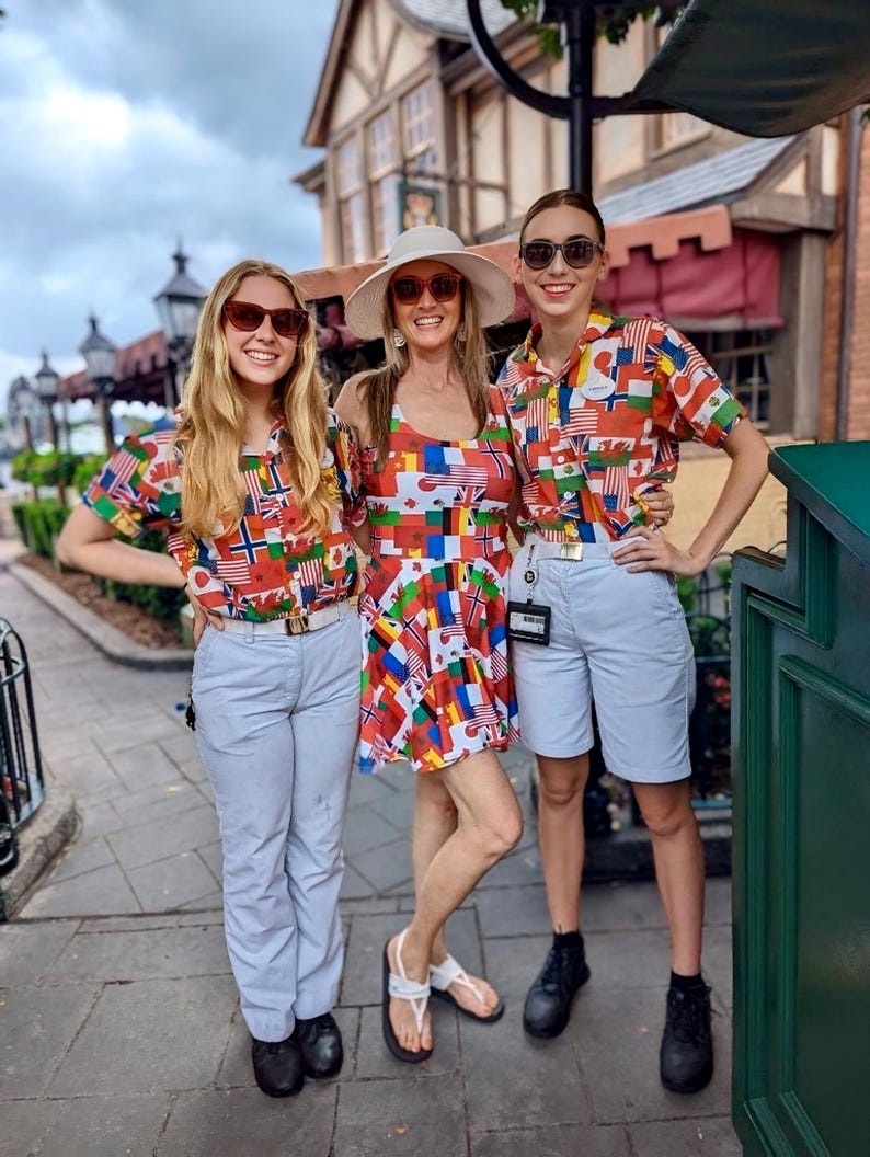 Puede incluir: Dos camisas de manga corta con botones y un vestido sin mangas, todos con un patr&oacute;n multicolor de varias banderas internacionales. Las camisas se combinan con pantalones y pantalones cortos de color azul claro, el vestido con un sombrero.
