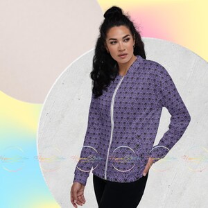 May include: A purple bomber jacket with a black and white pattern of ghosts. The jacket has a zipper closure and a stand-up collar.