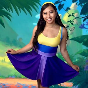 Könnte beinhalten: Ärmelloses Kleid mit gelbem Oberteil, blauem Mittelteil und lila Rock. Das Kleid hat einen passenden lila Gürtel und einen hellvioletten vertikalen Streifen. Ein gelbes Stirnband vervollständigt den Look.