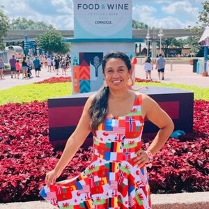Puede incluir: Un vestido sin mangas con un estampado integral de varias banderas internacionales en colores vibrantes que incluyen rojo, blanco, azul, amarillo y verde. El vestido tiene un escote redondo y una falda acampanada que llega por encima de la rodilla.