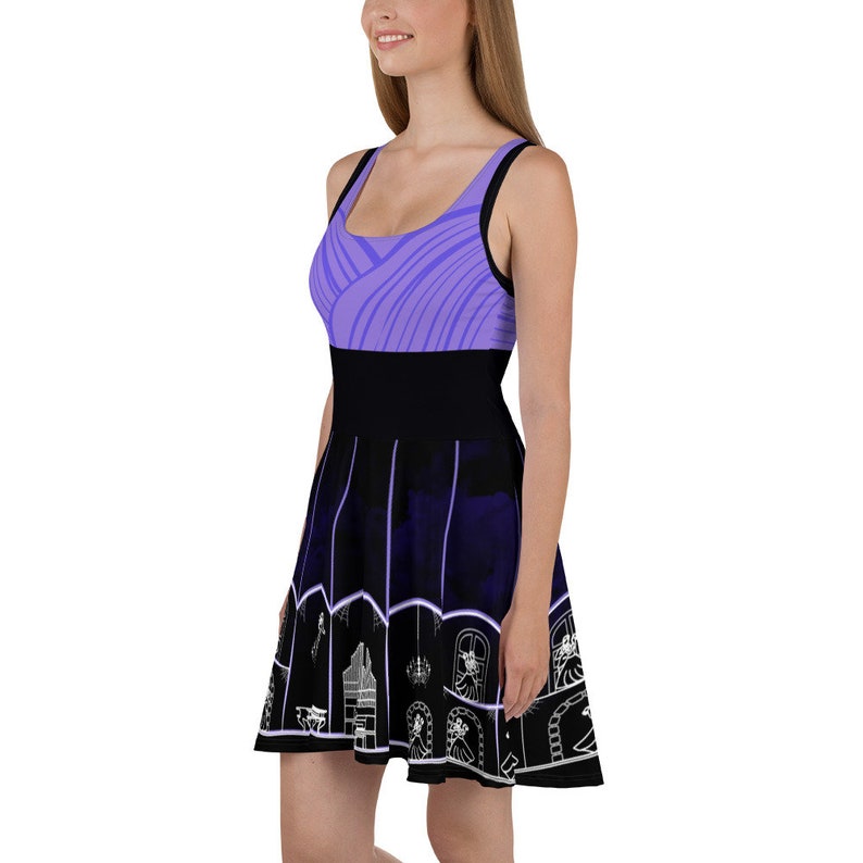 May include: A purple and black skater dress with a graphic print of a house with windows and a chandelier. The dress has a fitted bodice and a flared skirt.