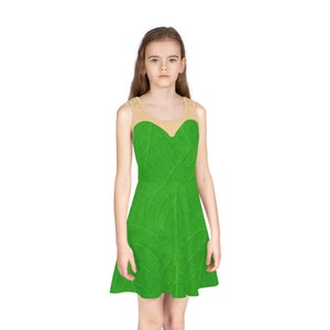 Puede incluir: Un vestido verde sin mangas con estampado de hojas. El vestido tiene un escote redondo y un corpiño ajustado. El vestido está hecho de una tela suave y cómoda.