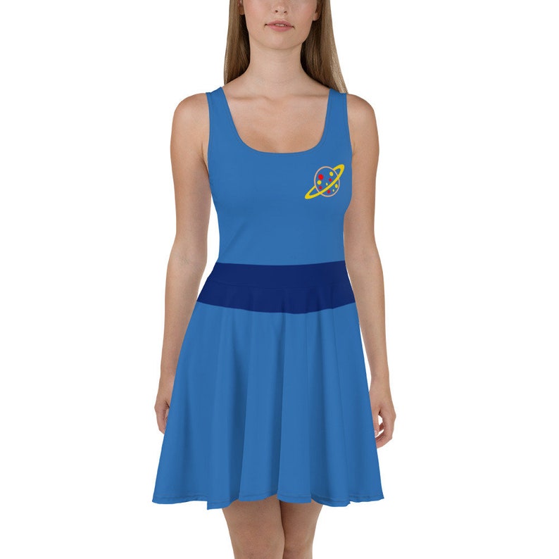May include: A blue and navy blue skater dress with a yellow and red planet graphic on the chest. The planet has a yellow ring around it.