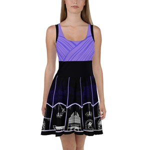 May include: A purple and black skater dress with a white design of a church organ, chandeliers, and a skull. The top of the dress is a solid purple with a geometric pattern. The bottom of the dress is black with a white design.