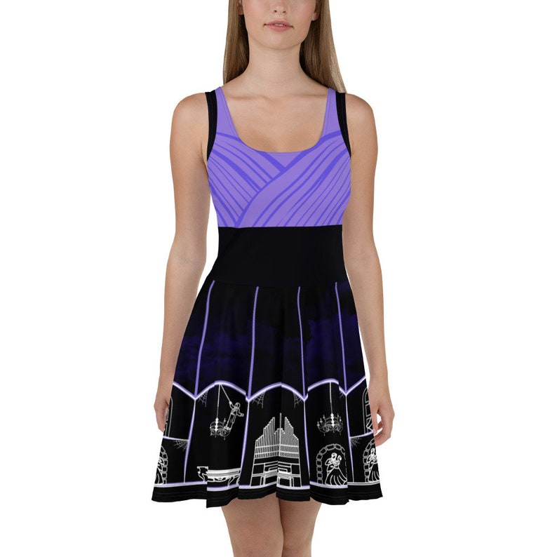 May include: A purple and black skater dress with a white design of a church organ, chandeliers, and a skull. The top of the dress is a solid purple with a geometric pattern. The bottom of the dress is black with a white design.